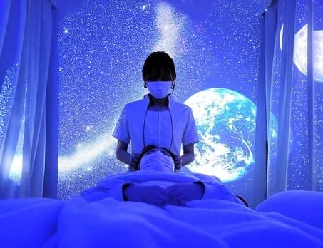 アリエスの施術風景。星空のプラネタリウム投影の下で受けるドライヘッドスパ